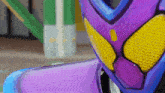 a close up of a purple helmet with a yellow stripe