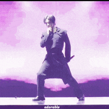 a man in a black suit is dancing on a stage with adorable written on the bottom of the image