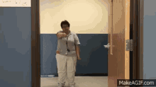 a woman is standing in front of an open door with makeagif.com written on the bottom