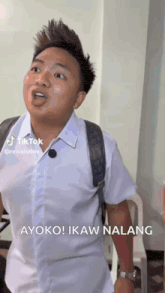 a man in a white shirt with a backpack is making a funny face and says ayoko ikaw nalang .