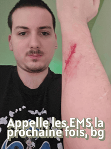 a man in a black shirt holds up his arm with the words " appele les ems la prochaine fois bg " on the bottom