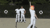 a man in white pants is dancing in front of a microphone while two other men stand behind him .