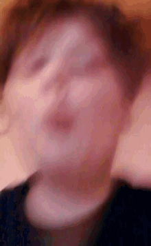 a blurry picture of a person 's face with their eyes closed .