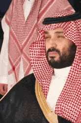 a man with a beard wearing a red and white checked scarf