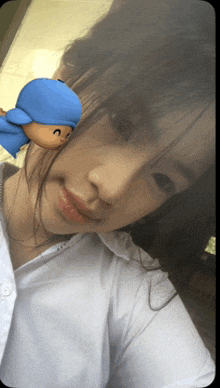 a close up of a woman 's face with a blue sticker on her face