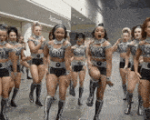 a group of women are dancing in front of a restrooms sign
