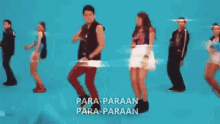 a group of people are dancing in front of a blue background with the words para-paraan para-paraan