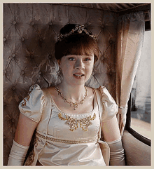 a woman wearing a white dress and a tiara sits in a car