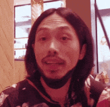 a man with long hair and a beard is wearing a face mask .