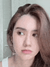 a close up of a woman 's face with long hair making a face .