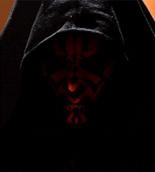 a close up of darth maul 's face with a black hood on