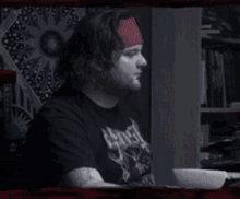 a man wearing a headband and a black shirt with a skull on it