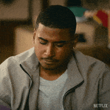 a man wearing a grey jacket with a netflix logo on it