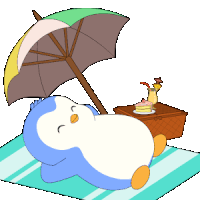 a penguin is laying on a blanket under an umbrella next to a cake