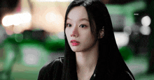 a woman with long black hair is looking at the camera .