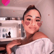 a woman with pink hearts on her face is looking at the camera