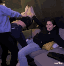 a woman in a black hoodie is sticking her tongue out while a man holds her butt