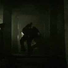a couple of people are fighting in a dark room in a dark room .