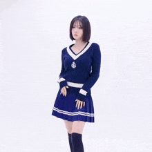 a woman wearing a blue sweater with a white anchor on it
