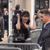 a woman in a fur coat is standing in front of a crowd