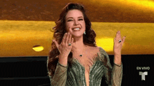 a woman in a green dress is smiling with her hands up in the air