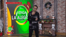 a man stands in front of a screen that says venga la alegr