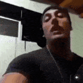 a man wearing a black shirt and a beanie is looking at the camera