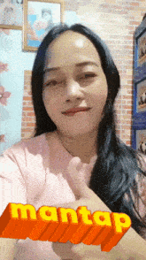 a woman is giving a thumbs up with the word mantap behind her