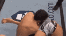 a man is laying on the ground in a wrestling ring with his head down .