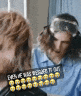 a man wearing headphones and goggles is talking to another man while wearing a blue shirt .
