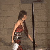 a woman in a plaid dress is walking down a street with korean writing