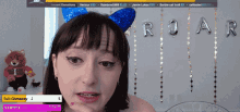 a woman wearing a blue cat ear headband is on a screen with the letters roar behind her