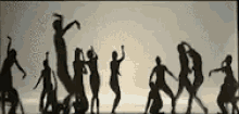 a silhouette of a group of people dancing on a stage
