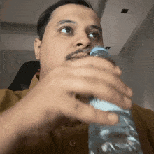 a man drinking water from a plastic bottle