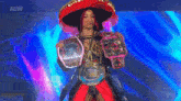 a woman in a sombrero is holding three wrestling belts .