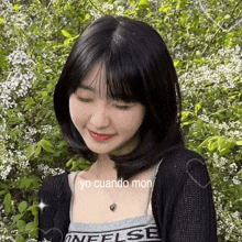 a girl wearing a black sweater and a necklace with yo cuando mon on it