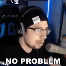 a man wearing headphones and glasses is sitting in front of a microphone with the words `` no problem '' .