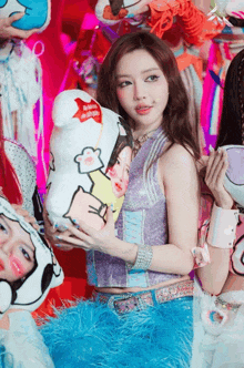 a girl in a purple top holds a stuffed animal with a picture of a girl on it