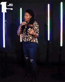 a woman wearing a leopard print shirt is smiling with the bet awards logo in the background