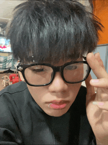 a young man wearing glasses and a ring in his lip