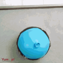 a person is cutting a blue balloon with a knife and the word yumup is on the bottom of the image