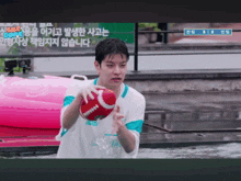 a man in a white shirt is holding a red football in his hands
