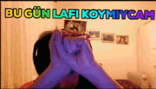 a person covering their face with their hands in front of a sign that says bu gun lafi koymiycam