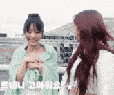 two women are standing next to each other and one has a green towel around her neck