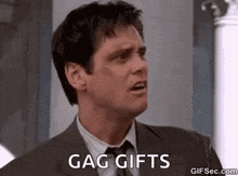 a man in a suit and tie is talking about gag gifts .