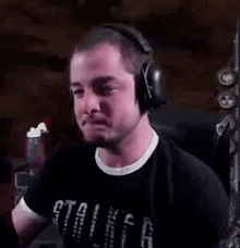 a man wearing headphones is sitting in a chair and making a face .