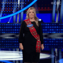 a woman is standing on a stage wearing a plaid scarf and a name tag that says marlene .