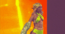 a woman in a neon green bikini and gloves is dancing on a stage