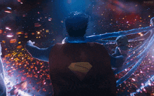 a man in a superman cape is holding a baby in his arms