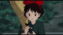 a girl with a red bow on her head is holding a cat